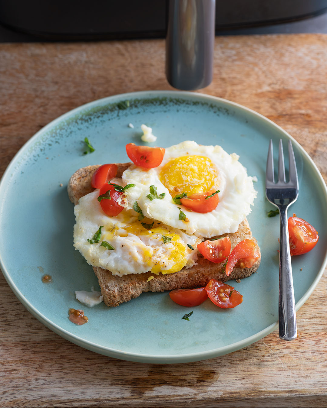 Tostada de huevos fritos hechos en freidora de aire con tomate